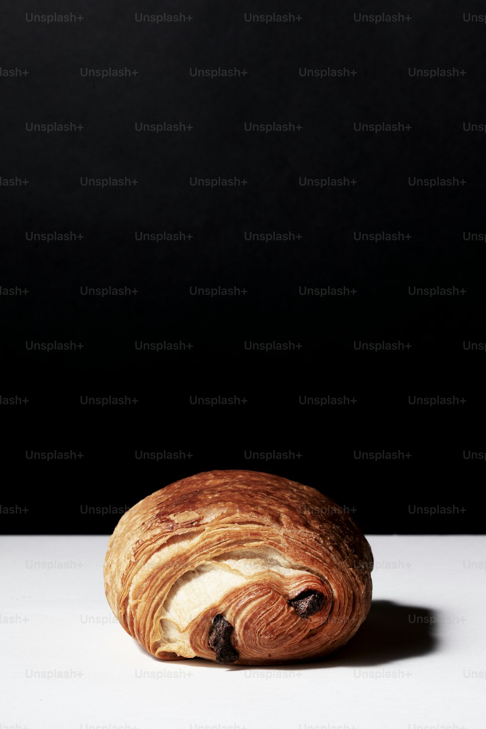 Ein Croissant sitzt auf einem weißen Tisch