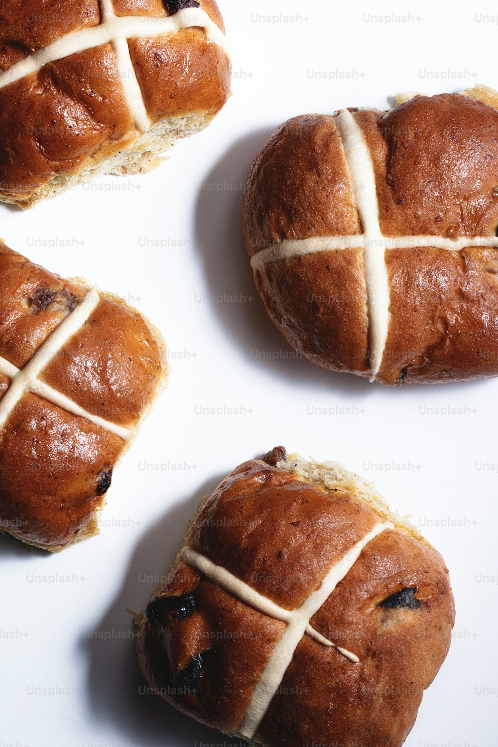 three hot cross buns on a white surface