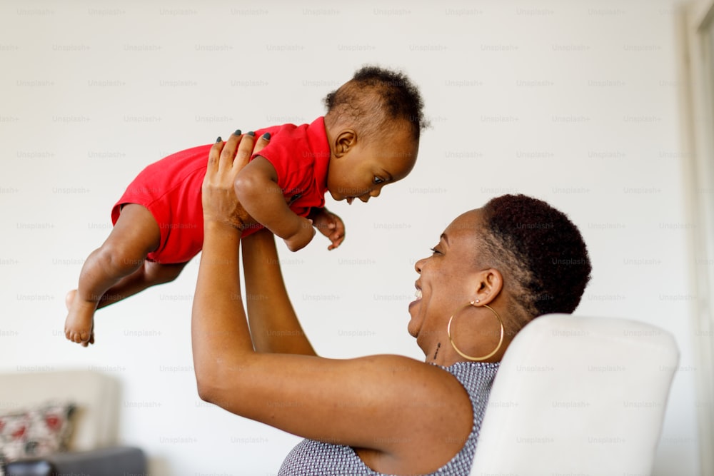 a woman holding a baby up in the air