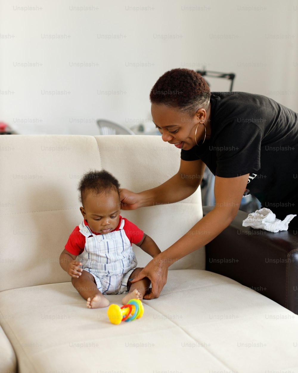 a woman playing with a baby on a couch