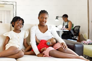a woman and two children sitting on a couch