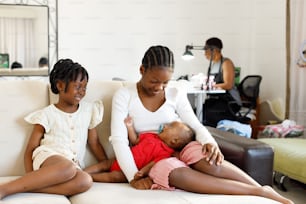 a woman and two children sitting on a couch