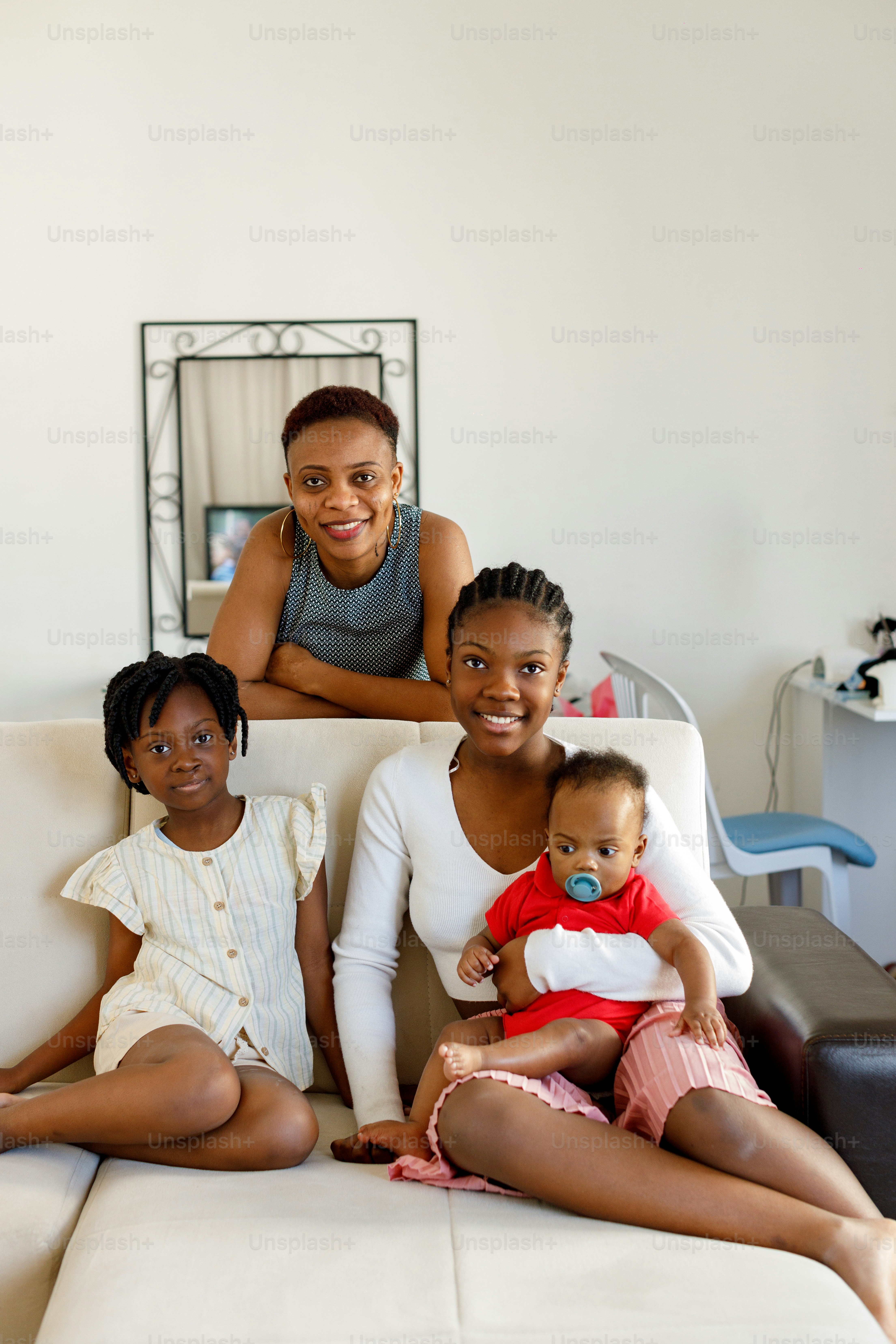 Eine Frau sitzt mit zwei Kindern auf einer Couch