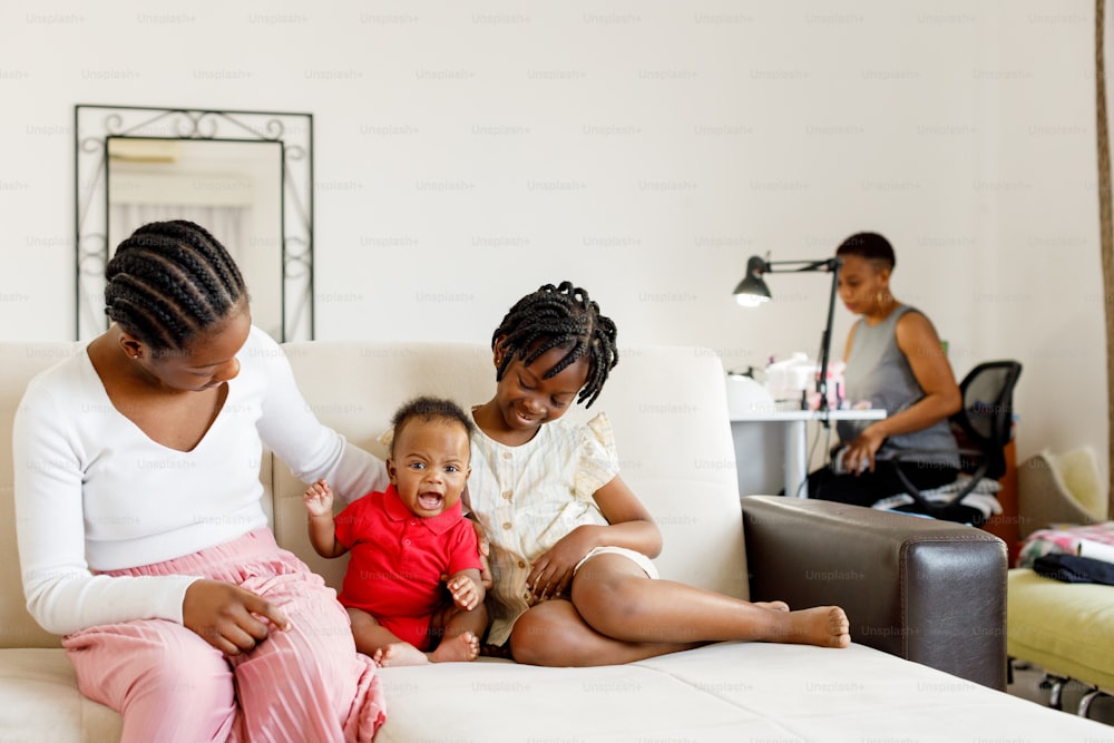 a woman and two children sitting on a couch