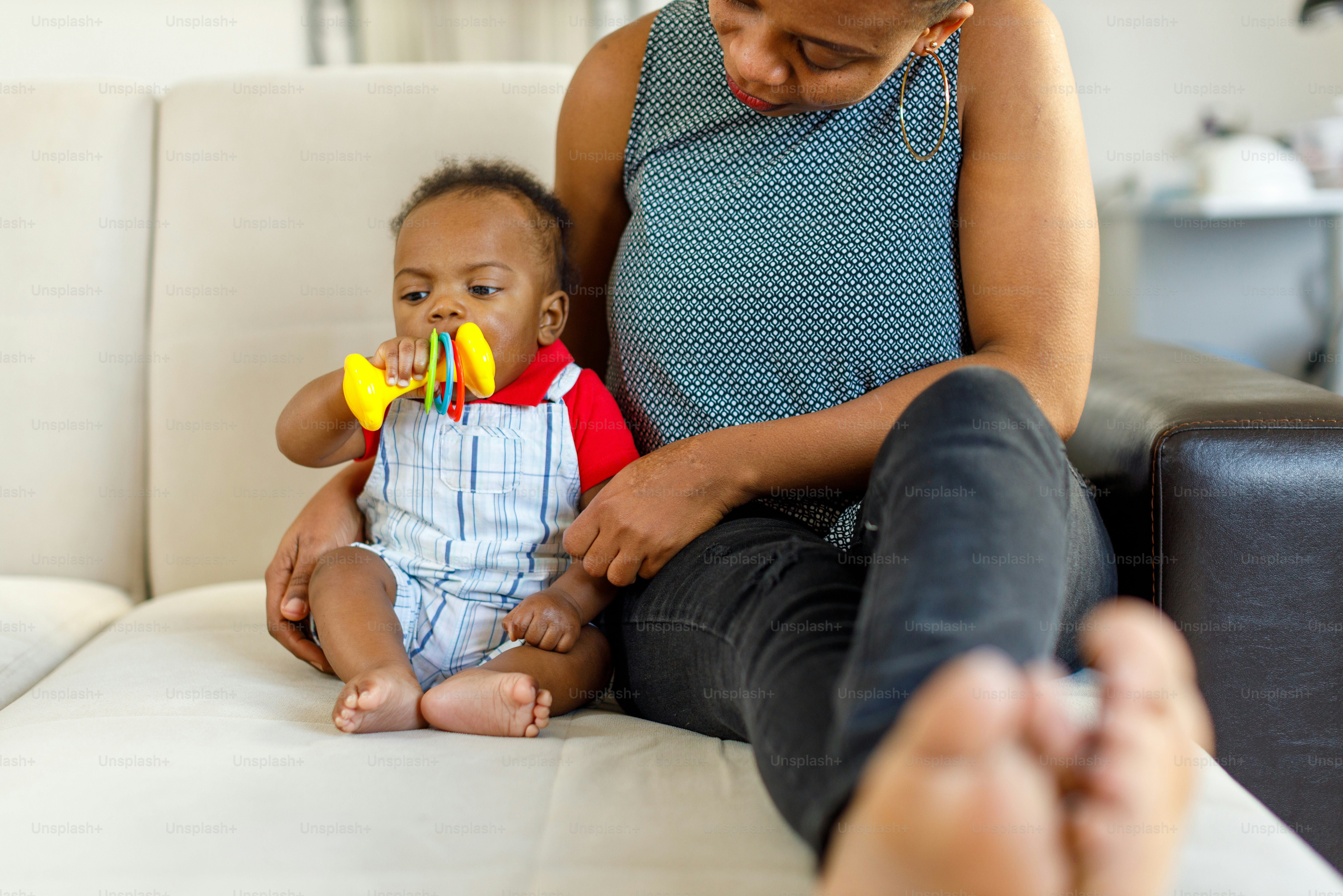 a woman sitting on a couch holding a baby