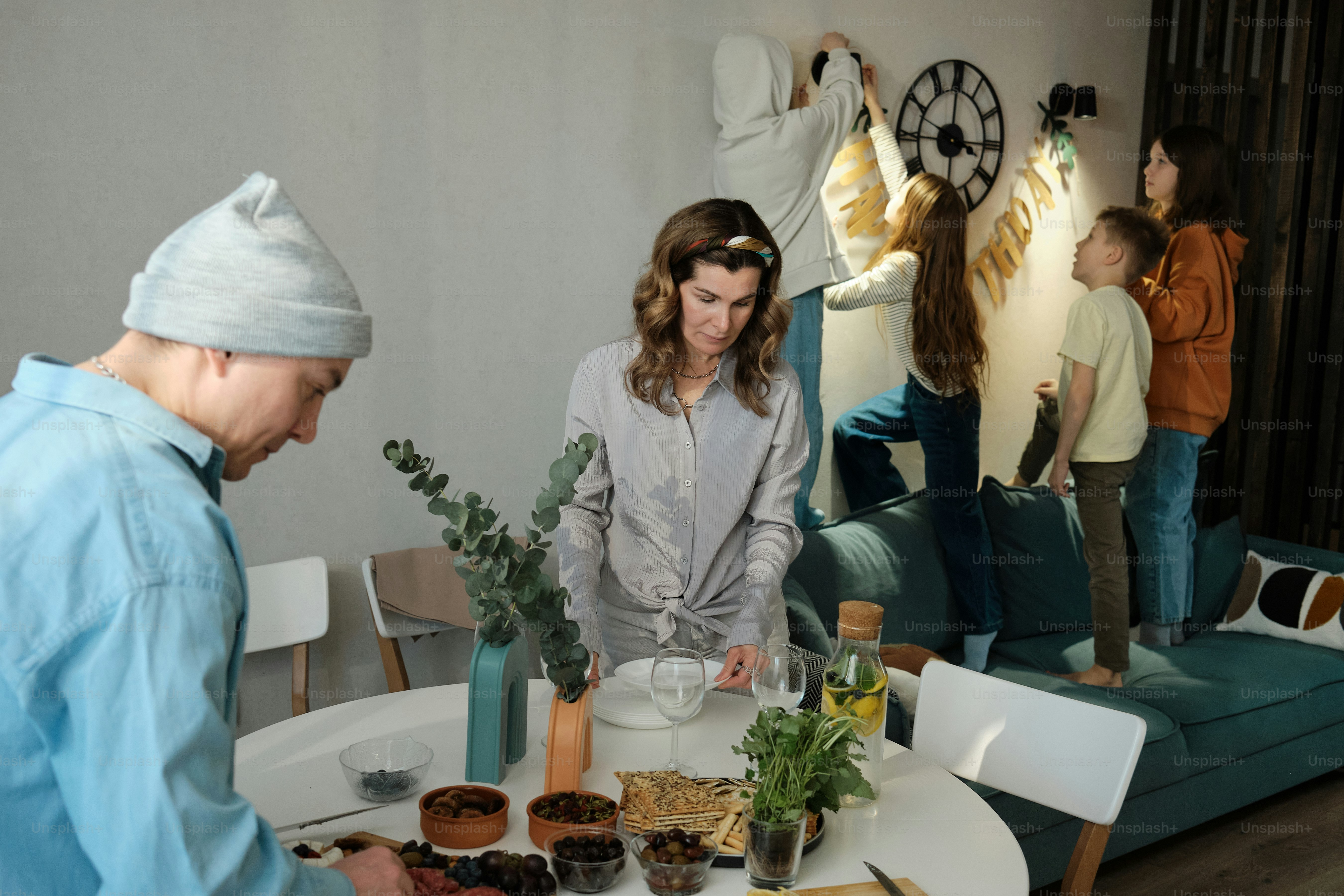 A group of people standing around a table with food on it photo ...