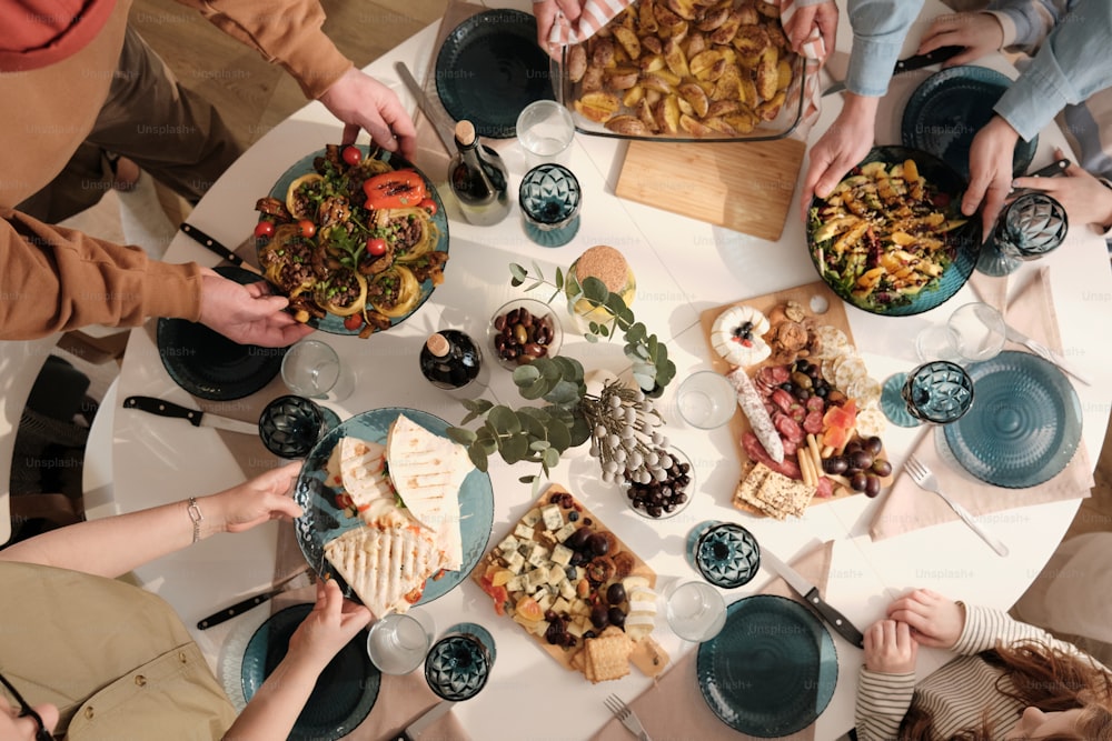 Eine Gruppe von Menschen sitzt um einen Tisch mit Tellern mit Essen