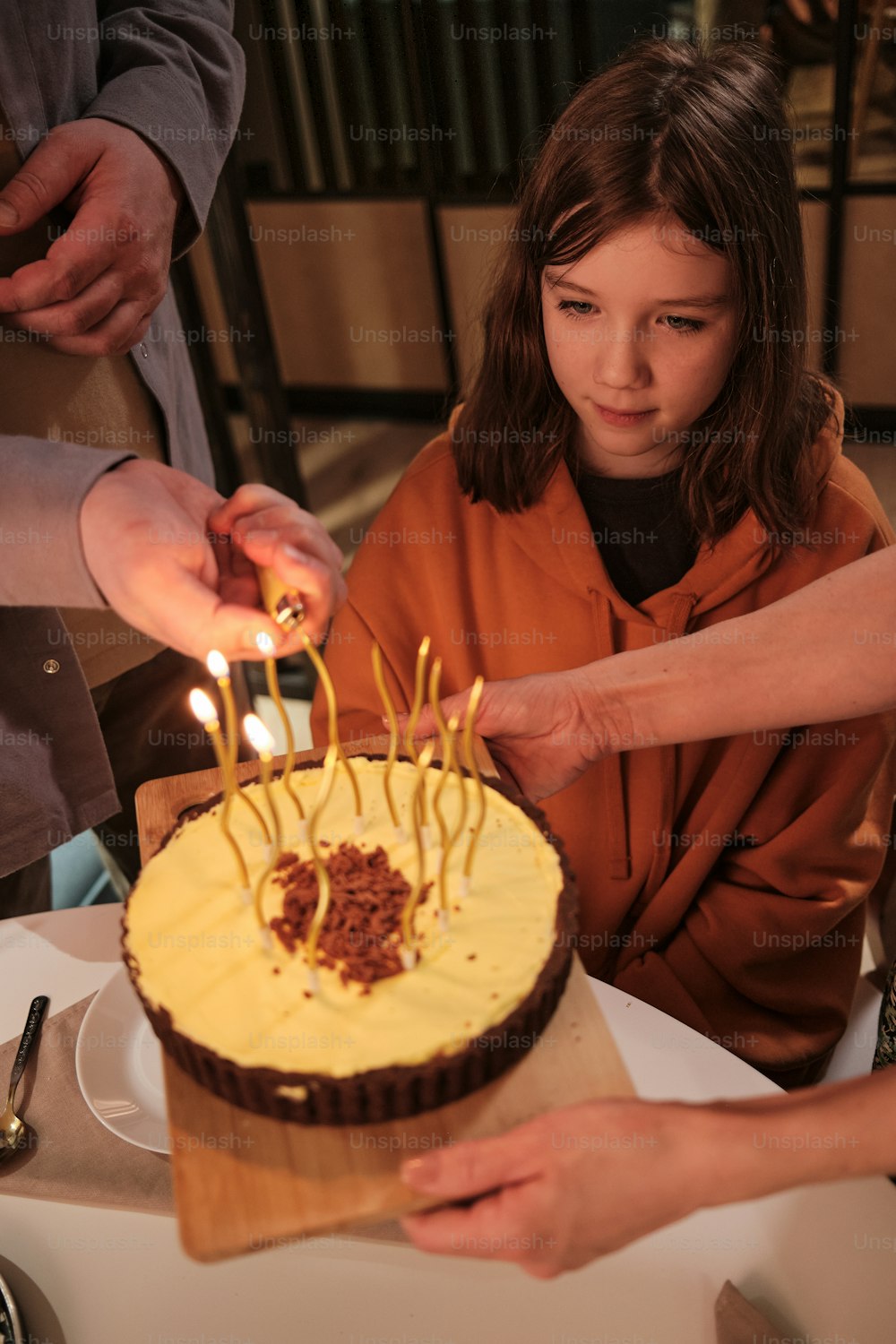 Ein kleines Mädchen, das sich darauf vorbereitet, Kerzen auf ihrem Geburtstagskuchen auszublasen