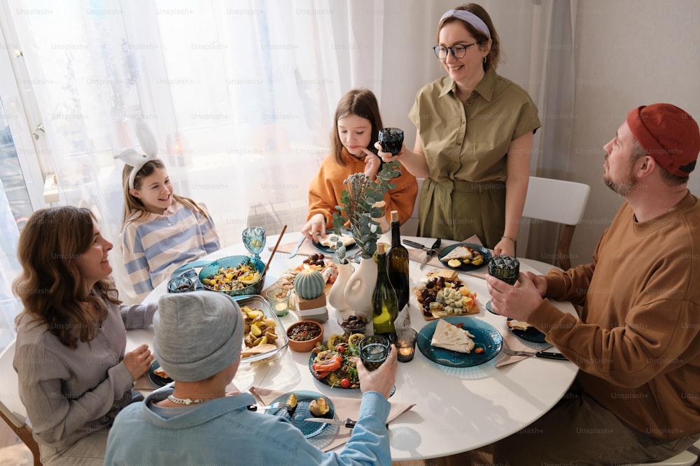 Eine Gruppe von Menschen, die um einen Tisch sitzen und Essen essen