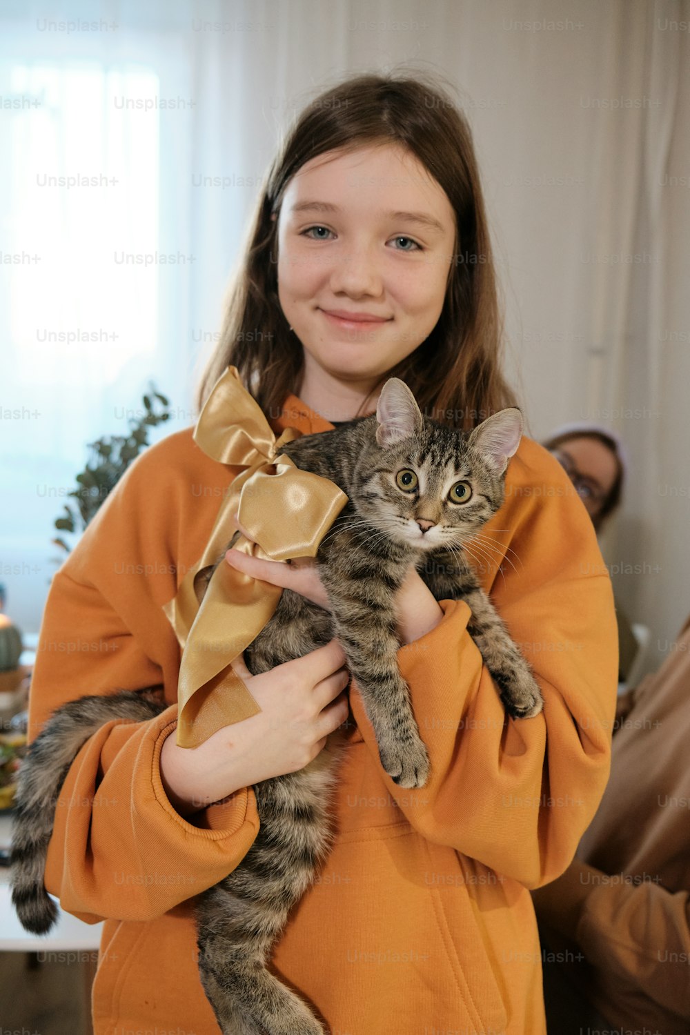 Una ragazza che tiene un gatto tra le sue braccia