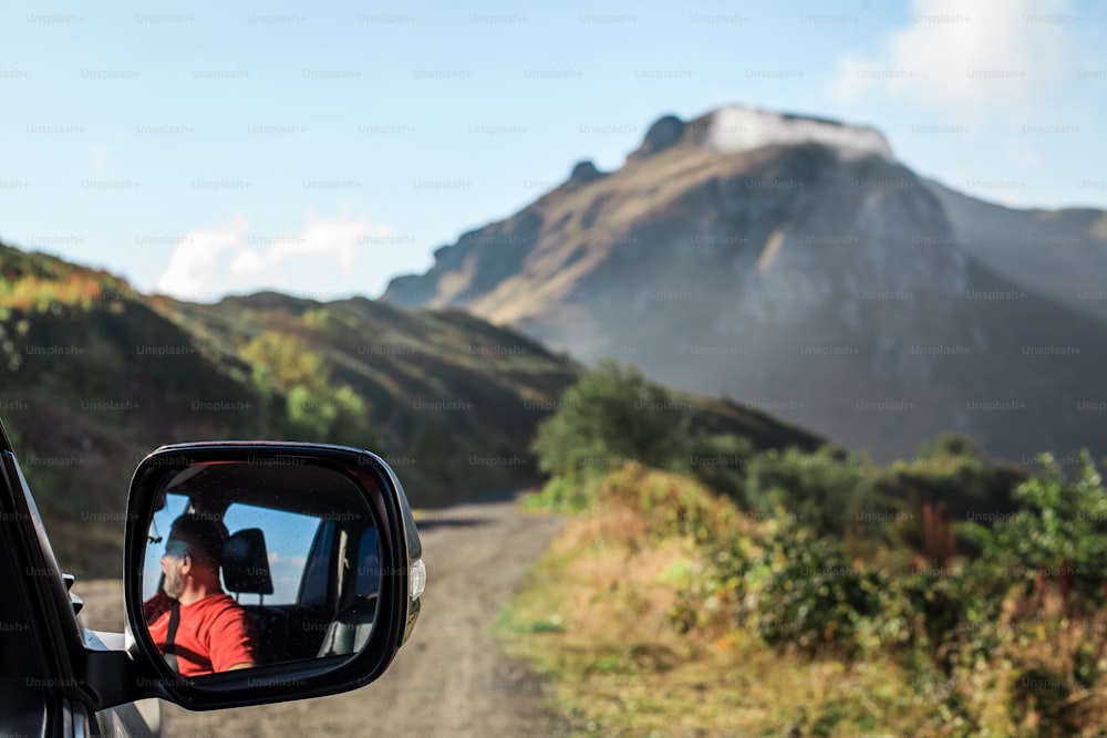 a man taking a picture of himself in the side mirror of a car