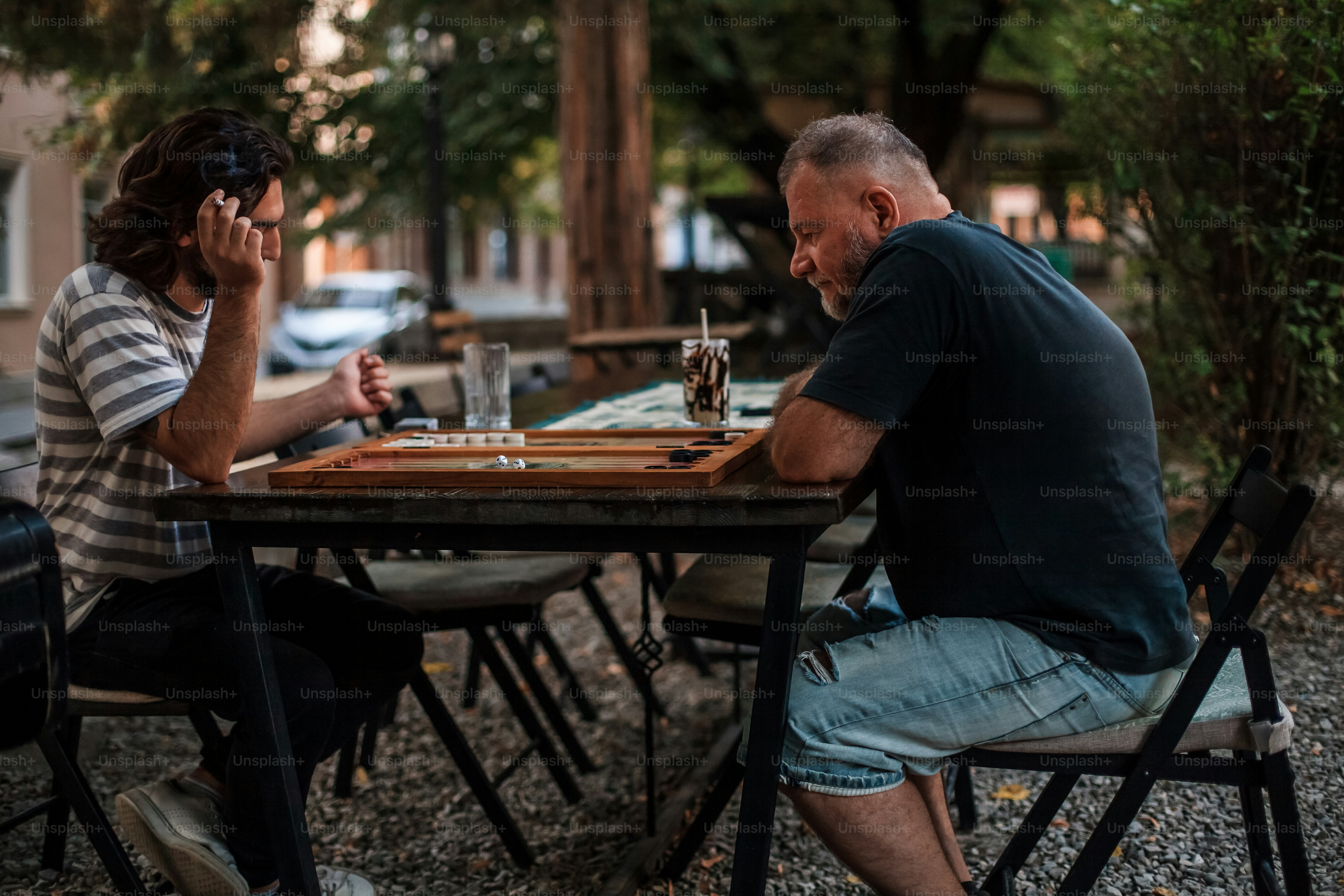 a man and a woman sitting at a table playing chess