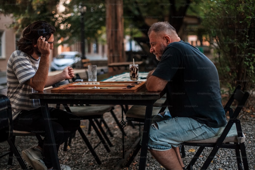 テーブルに座ってチェスをする男女