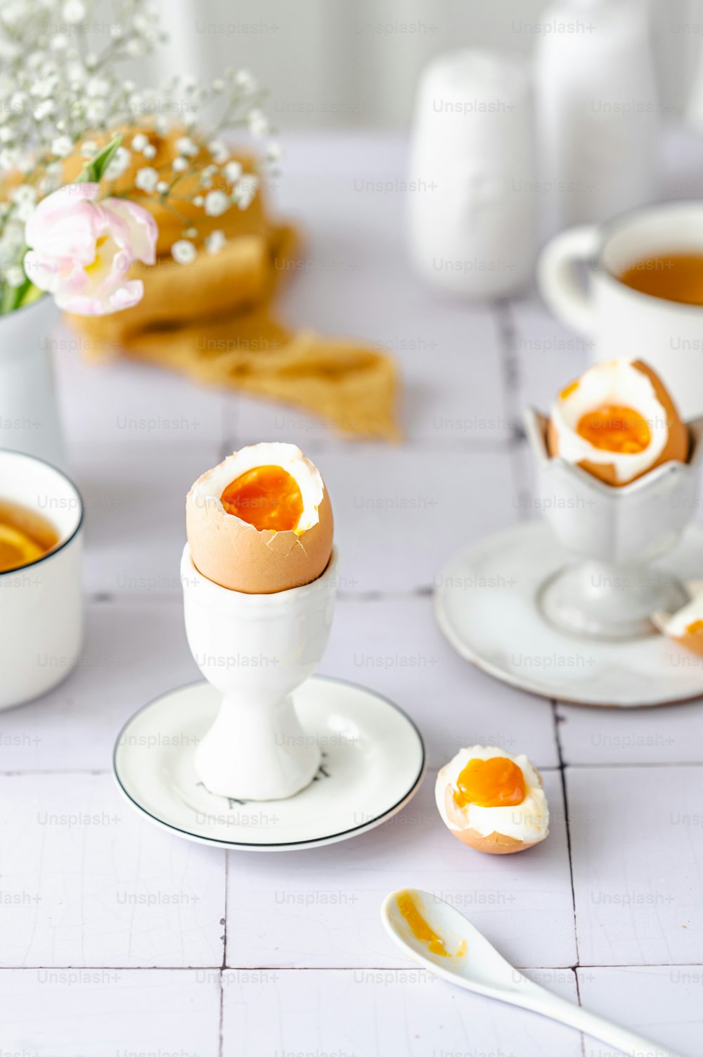 uma mesa coberta com ovos e xícaras de chá