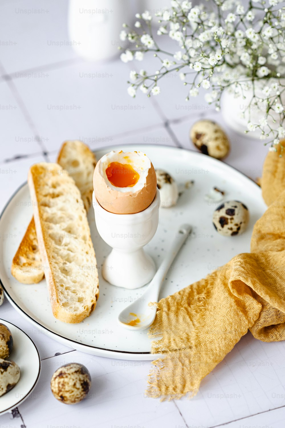 ein weißer Teller mit Brot und einem Ei