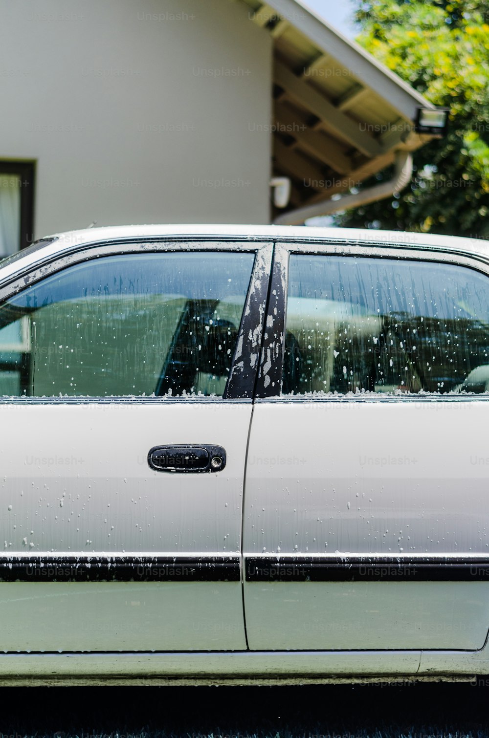 a white car parked in front of a house