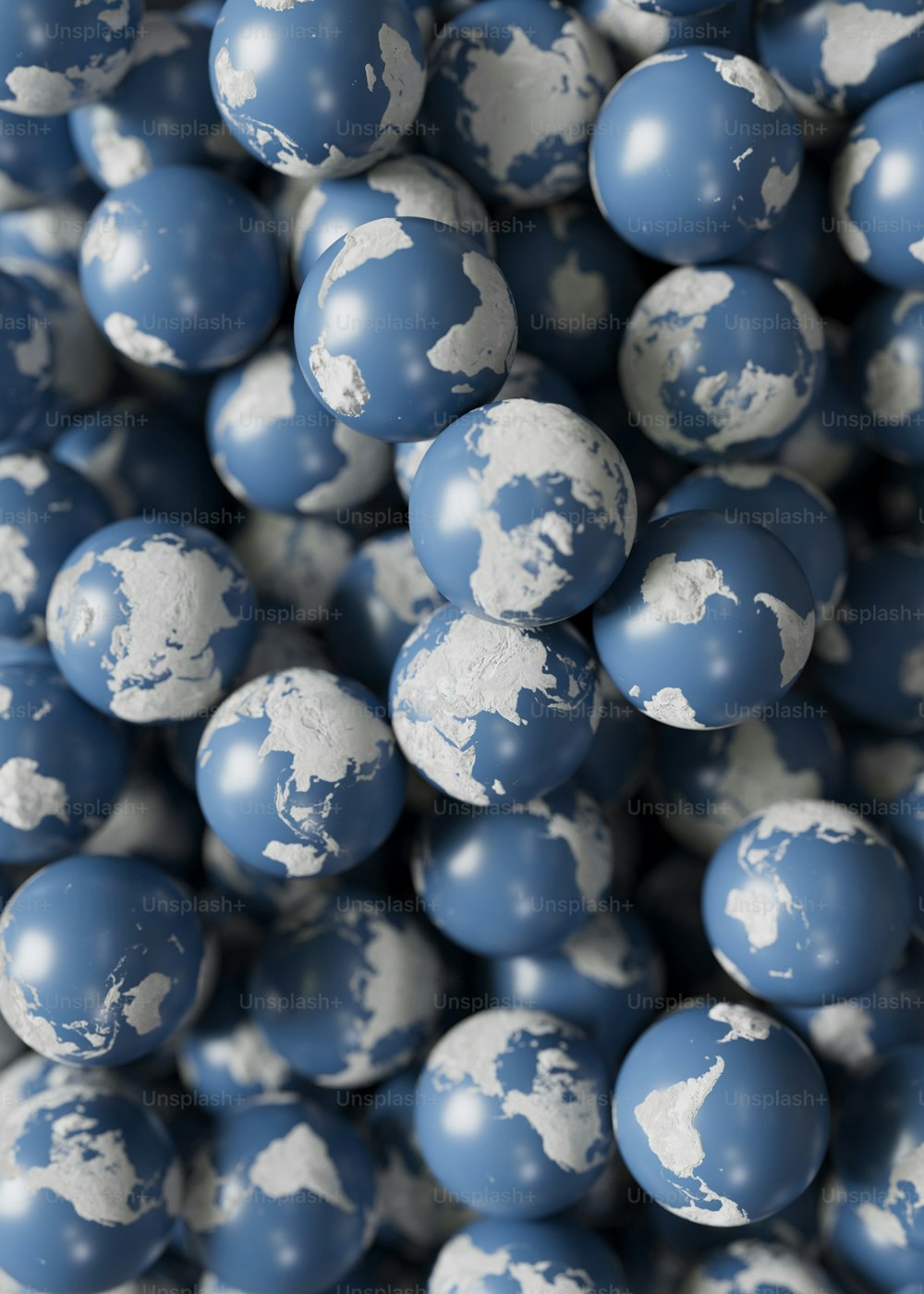 世界地図が描かれた青と白のボールの山