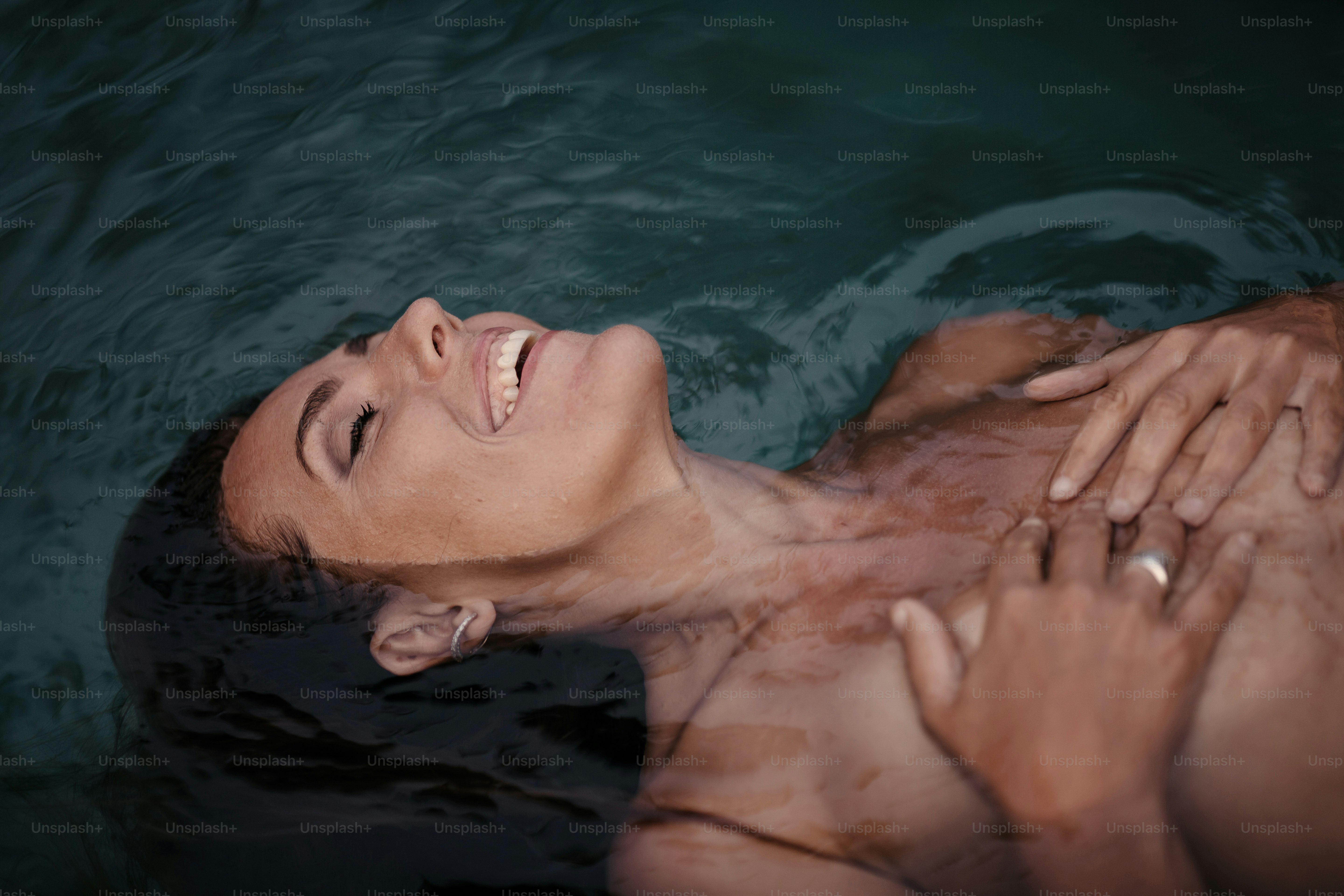 a man is in the water with his hands on his chest