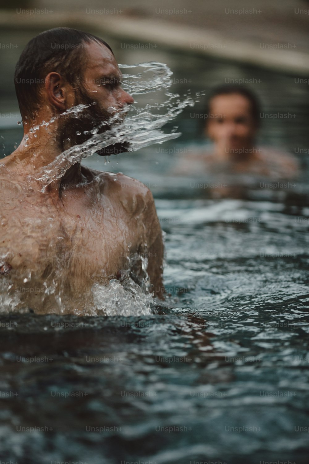a man and a woman swimming in a pool of water
