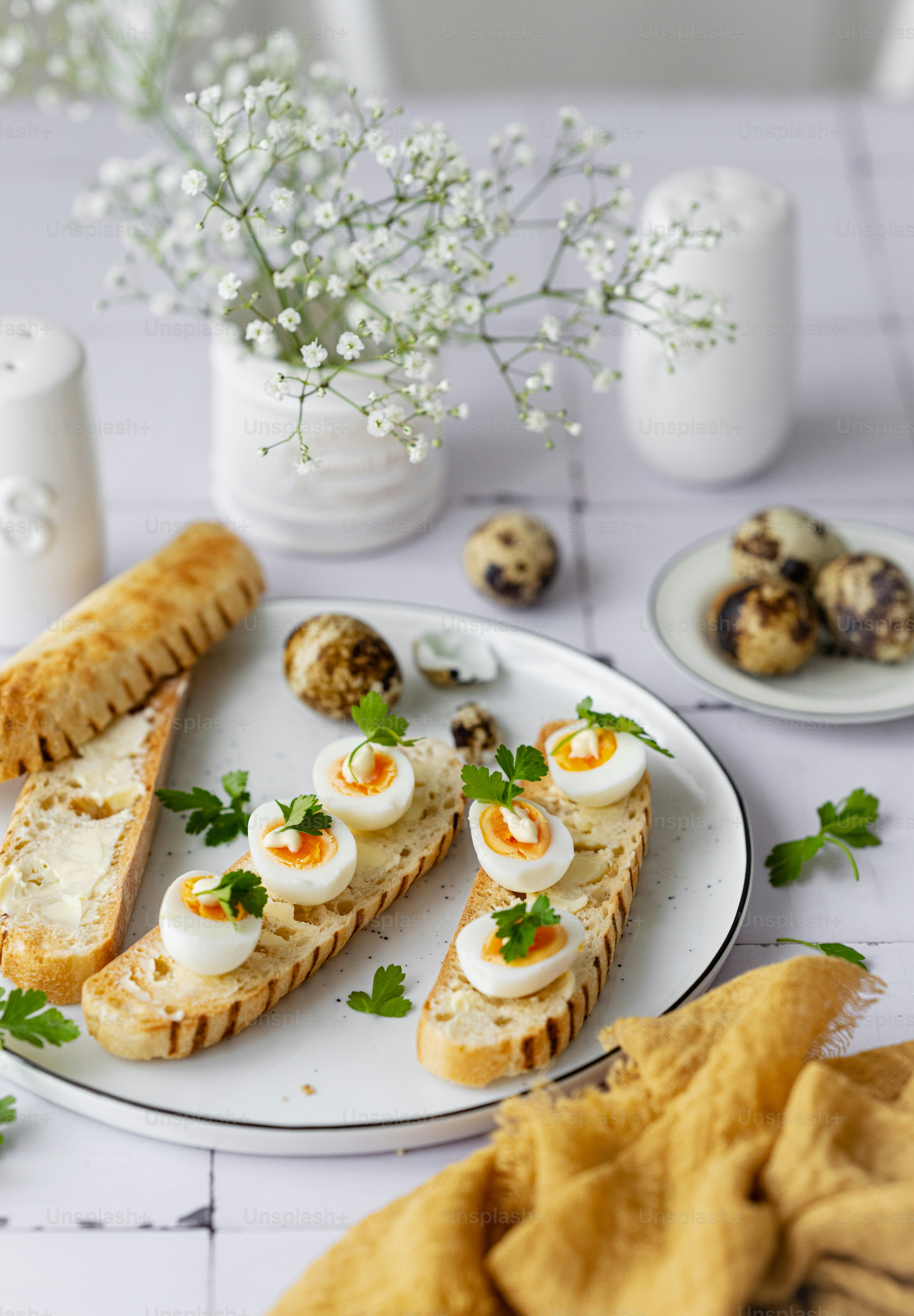 a plate of food on a table with a vase of flowers
