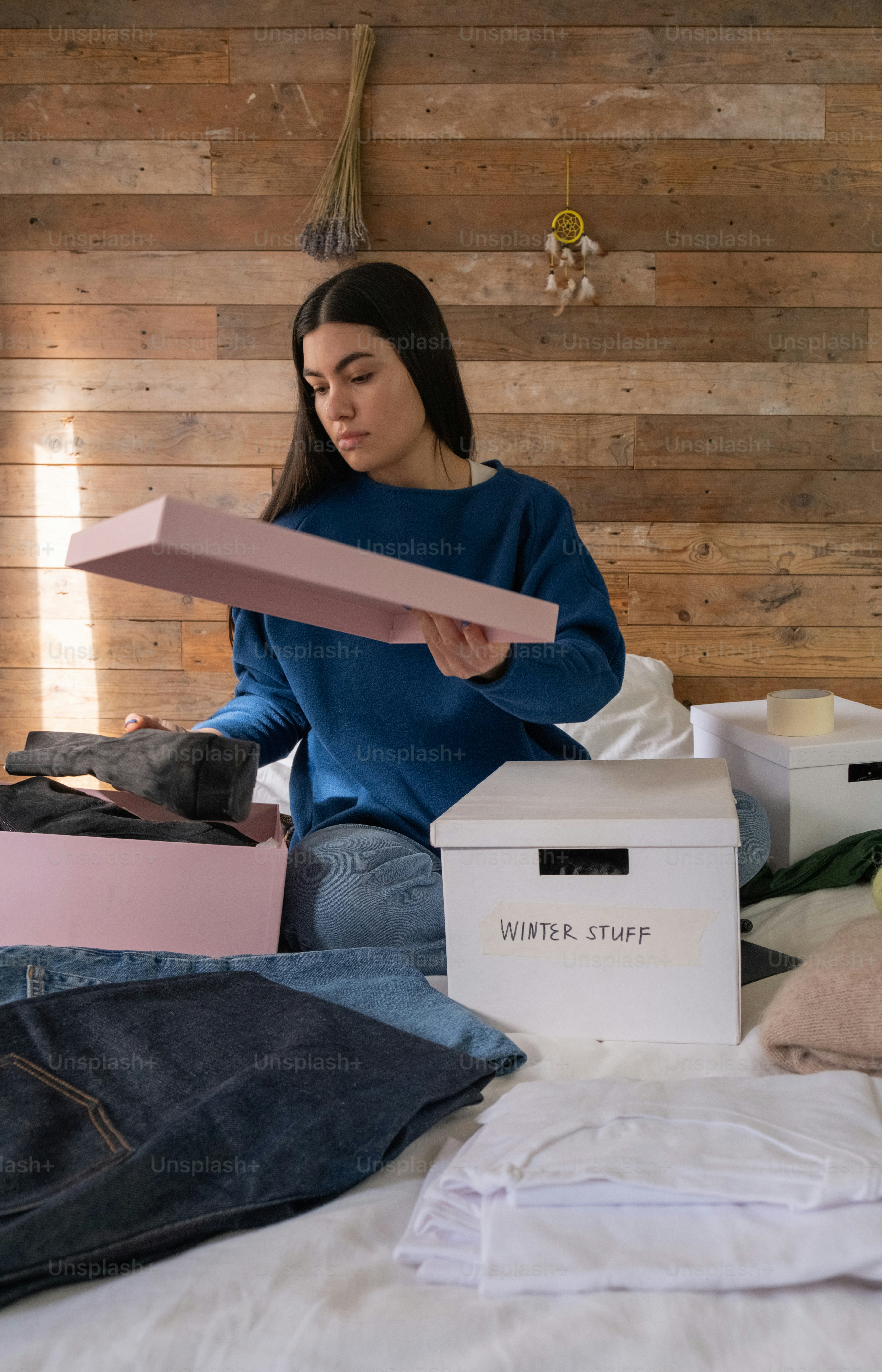 uma mulher sentada em uma cama segurando um pedaço de papel