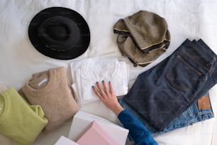 a person laying on a bed next to a pile of clothing