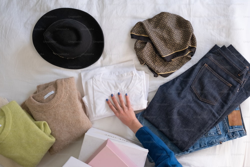 Una persona acostada en una cama junto a un montón de ropa