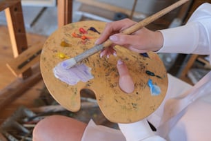 a person holding a paintbrush and a paint palette