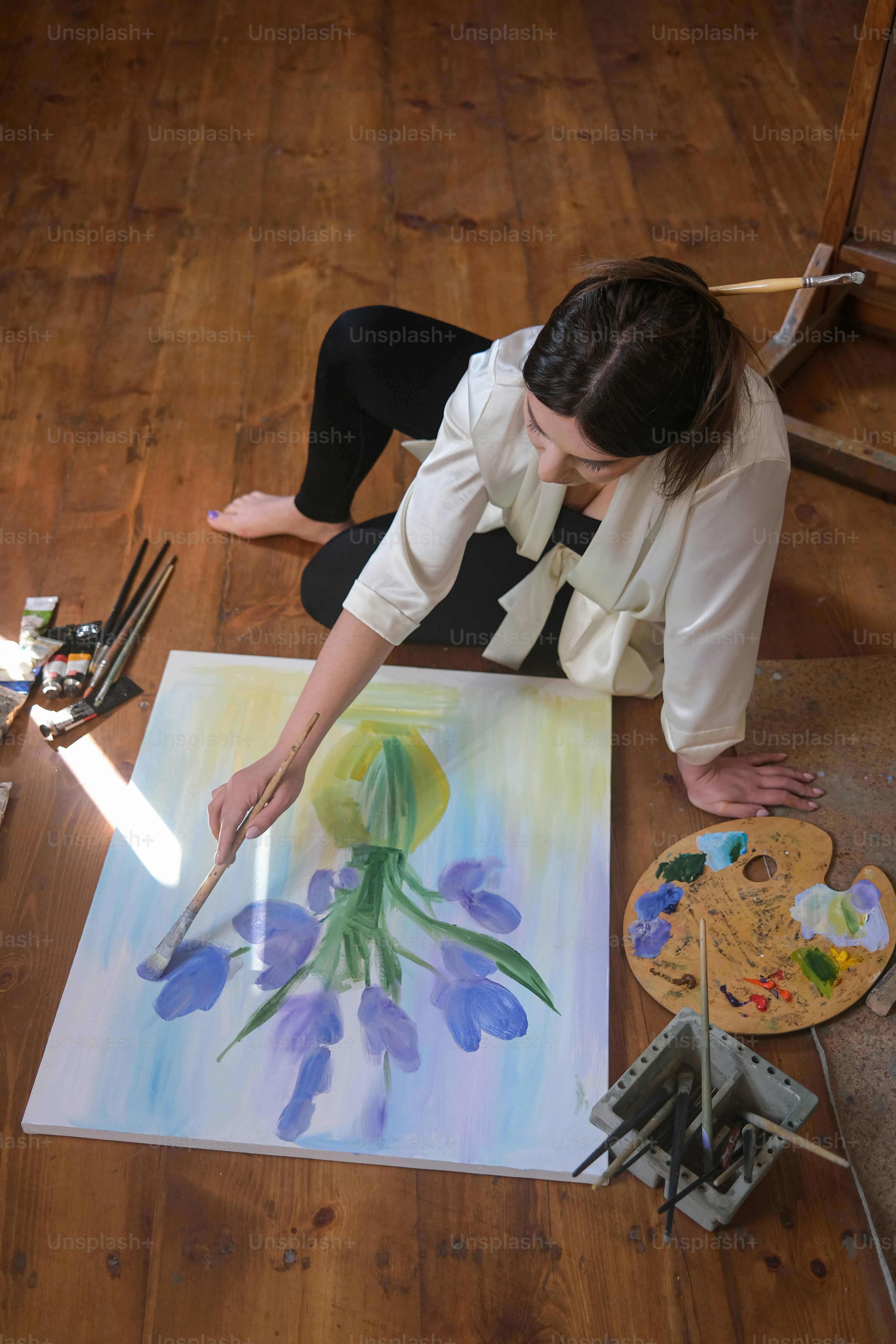 Foto Una mujer sentada en el suelo pintando un cuadro – Cuadro Imagen ...