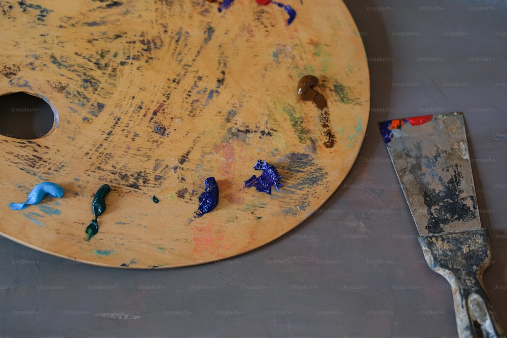una paleta de pintura y una espátula sobre una mesa