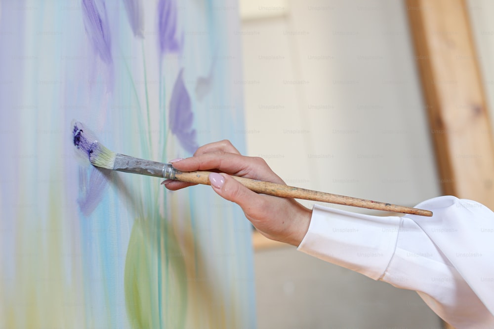 a close up of a person holding a paintbrush
