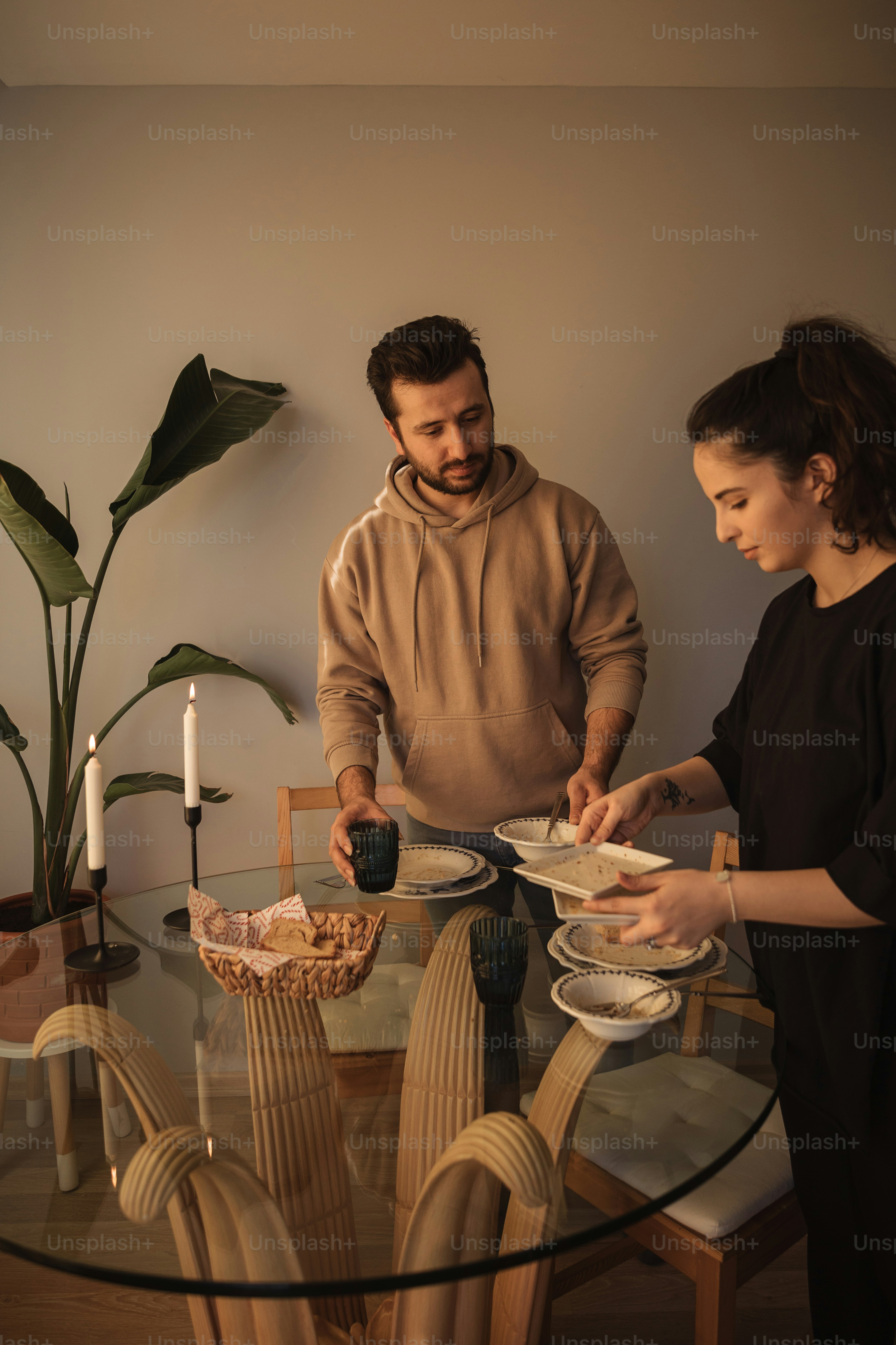 Un hombre y una mujer están preparando comida en una mesa de vidrio ...