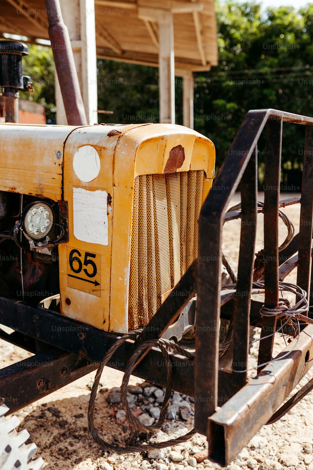 Un trattore giallo seduto in cima a un campo sterrato