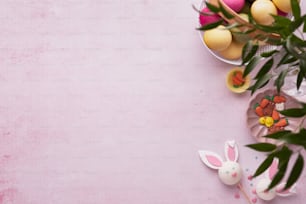 a pink table topped with lots of decorated eggs