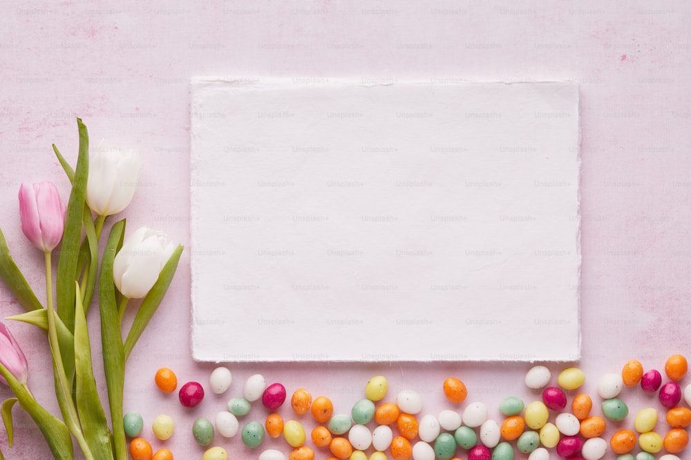 un foglio di carta bianco circondato da caramelle e fiori