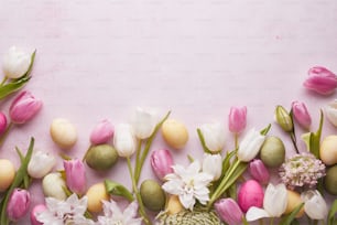 a bunch of flowers and eggs on a pink background