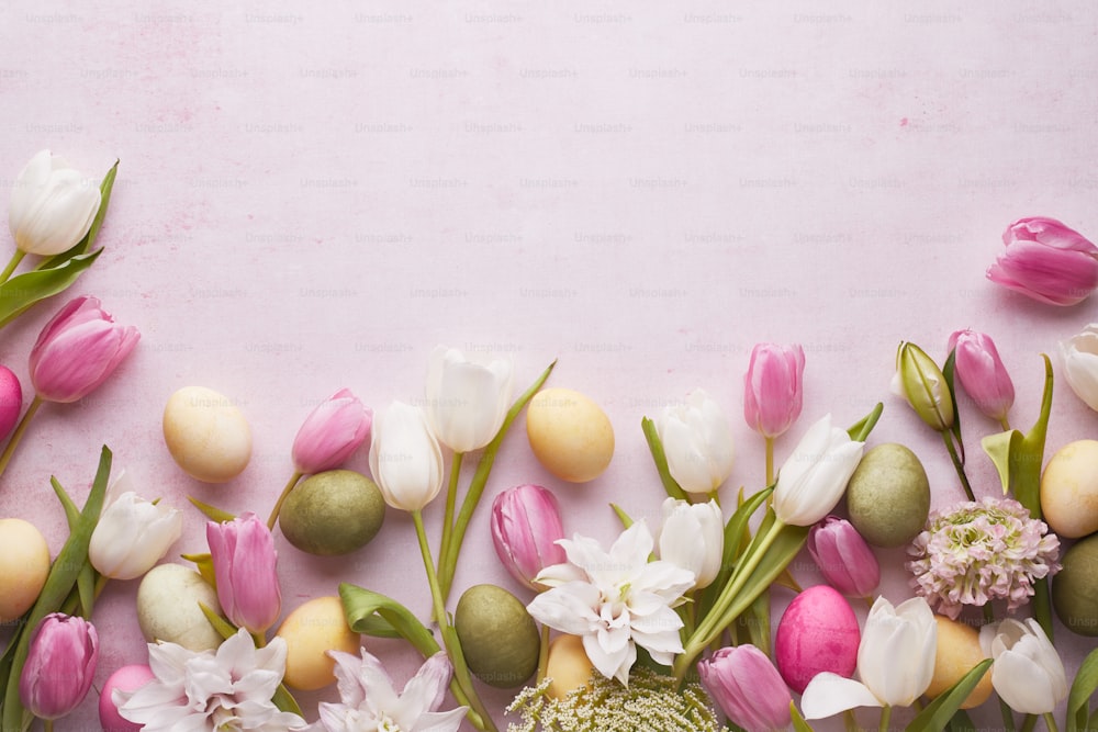 a bunch of flowers and eggs on a pink background