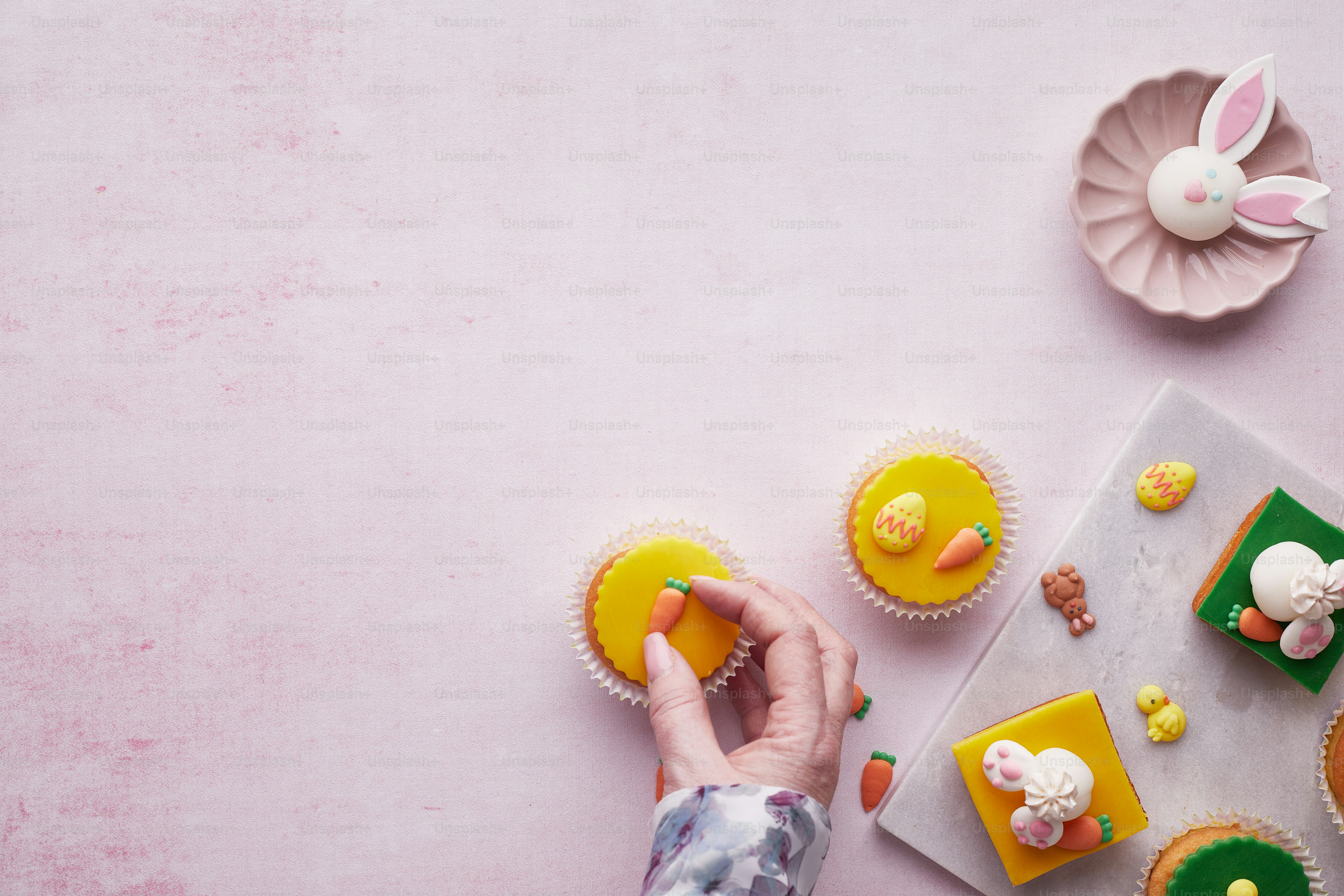 uma pessoa decorando cupcakes em uma mesa