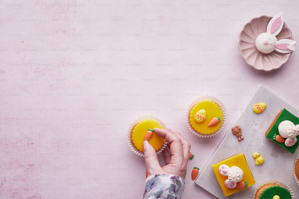 une personne décorant des cupcakes sur une table