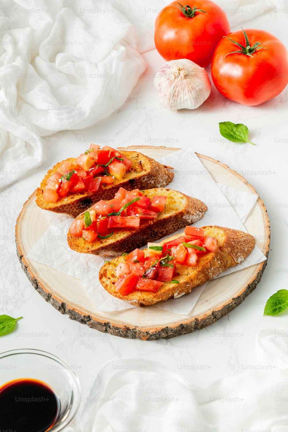 three pieces of bread with tomatoes and basil on a plate