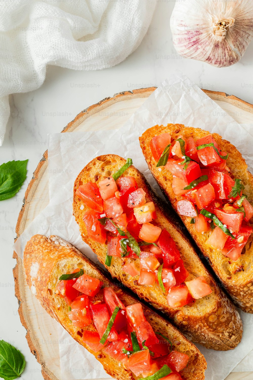 two pieces of bread with tomatoes and basil on top