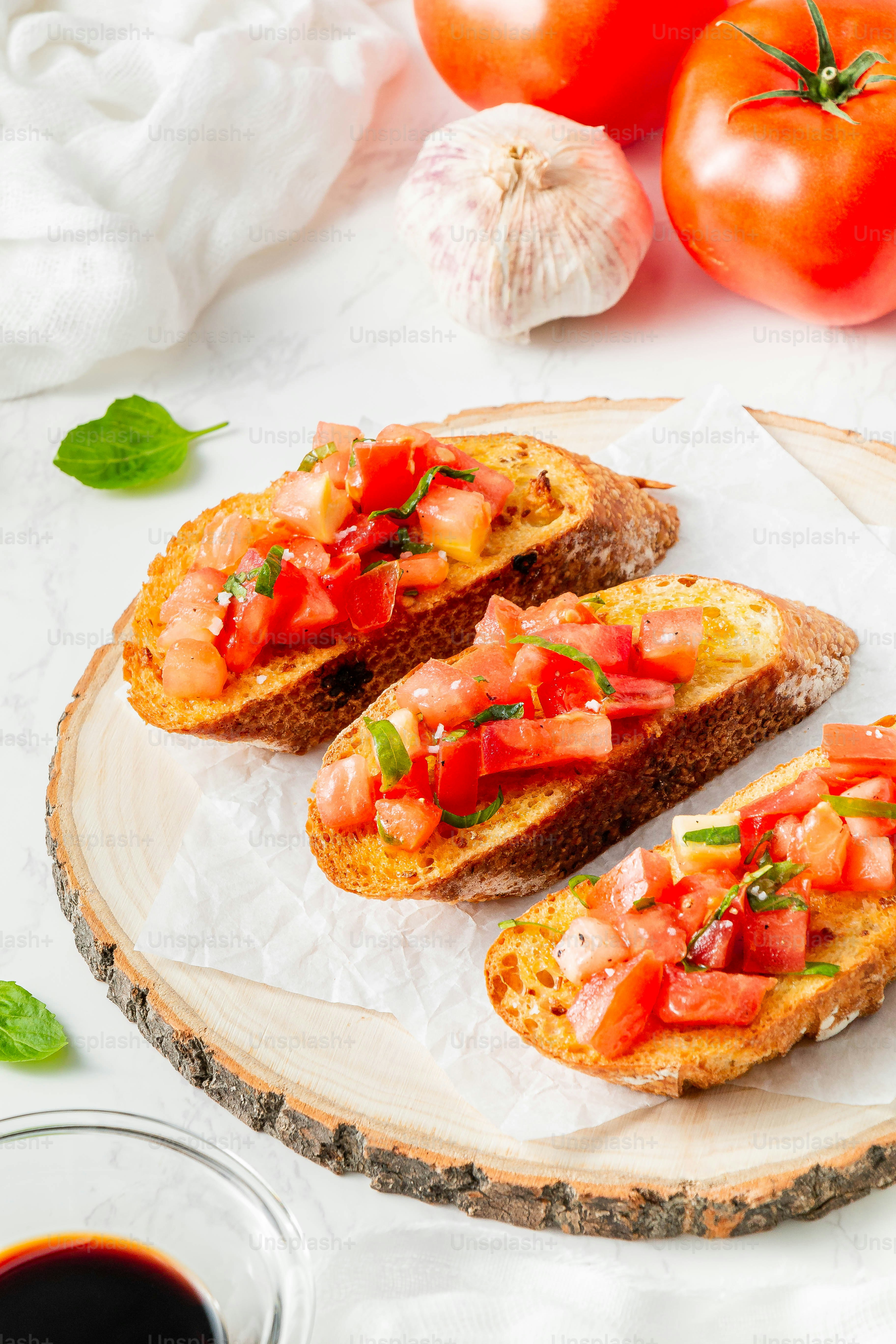 two pieces of bread with tomatoes and basil on top