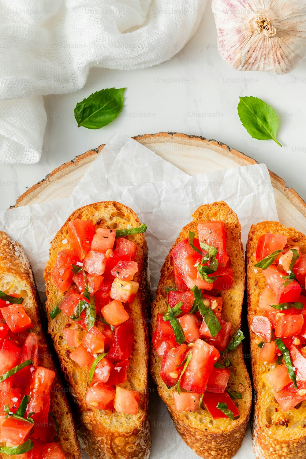 three pieces of bread with tomatoes and basil on top