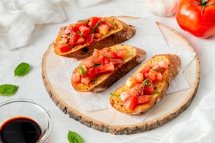 two pieces of bread with tomatoes on top of it