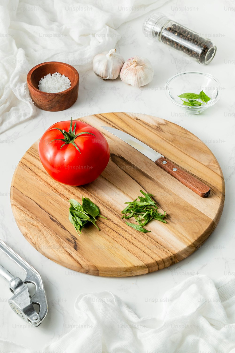 une planche à découper en bois avec une tomate dessus