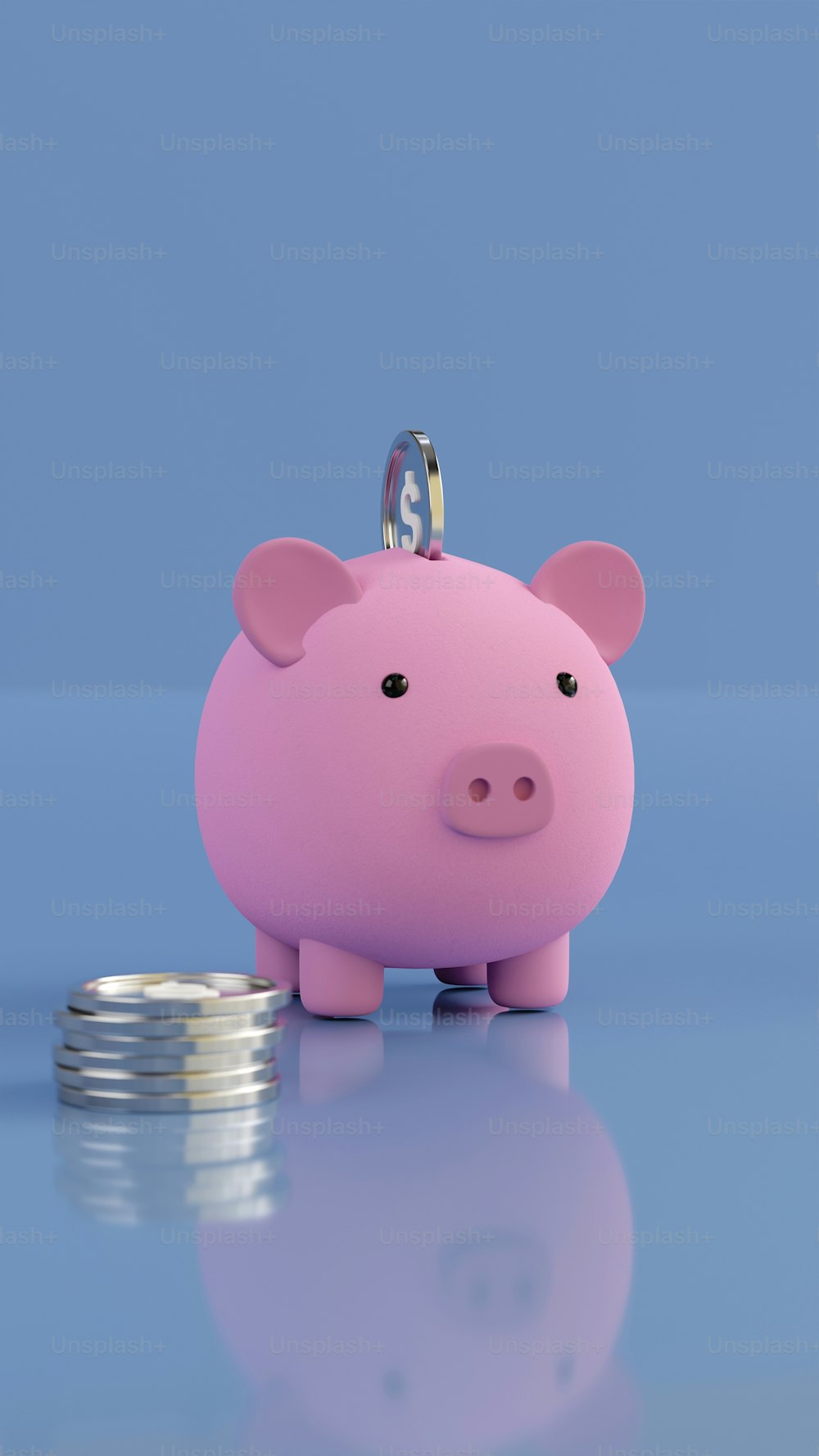 a pink piggy bank sitting next to a stack of coins