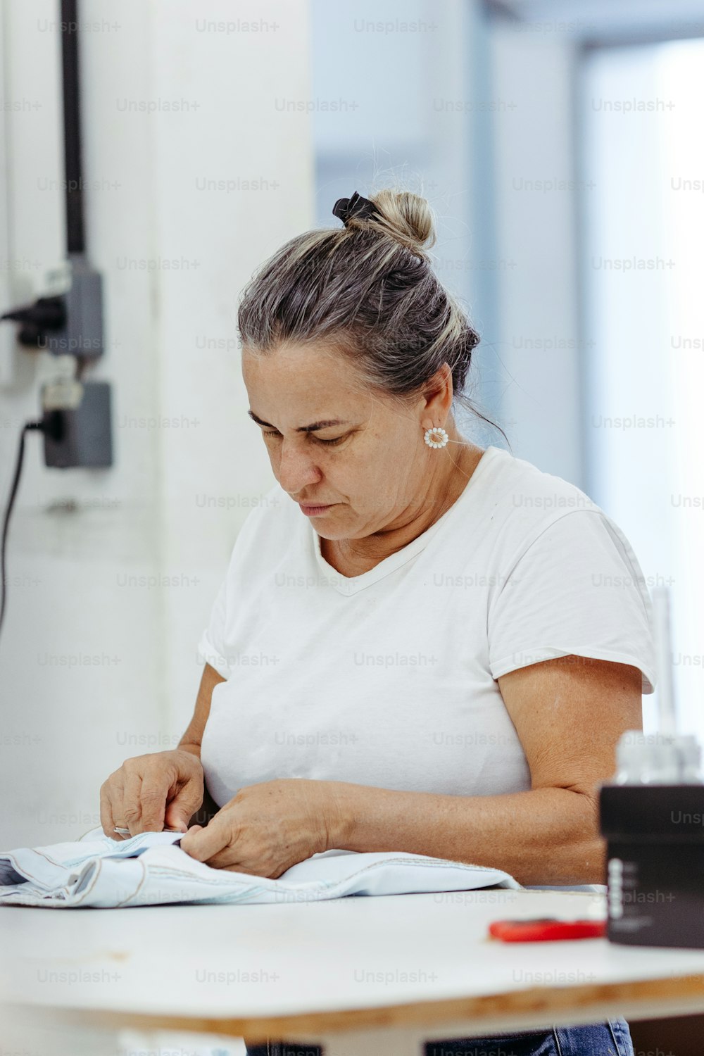 Una mujer sentada en una mesa trabajando en un pedazo de papel