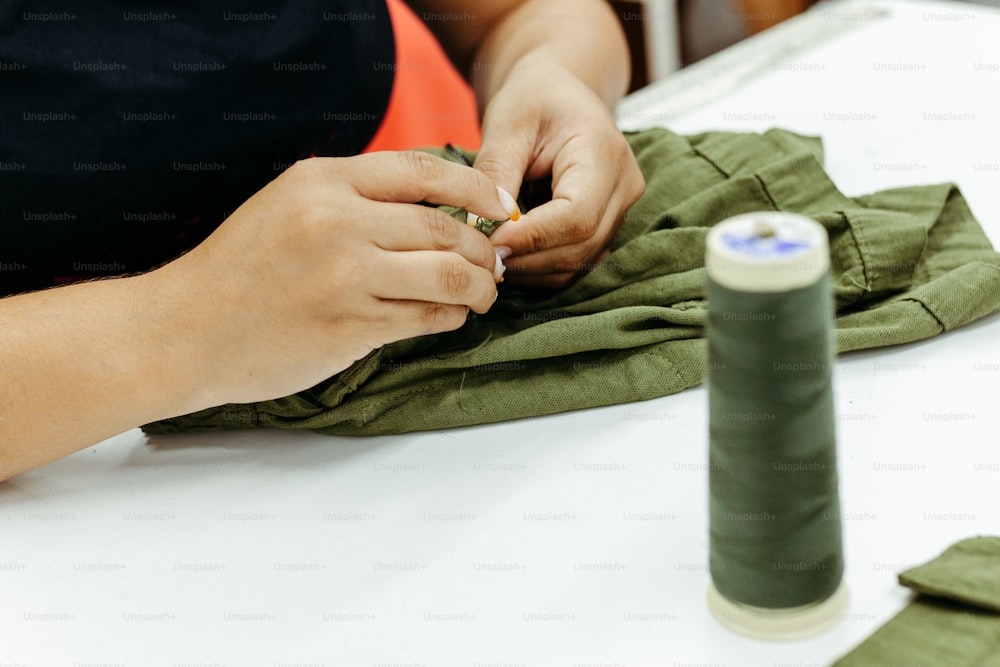 a person is sewing on a piece of cloth