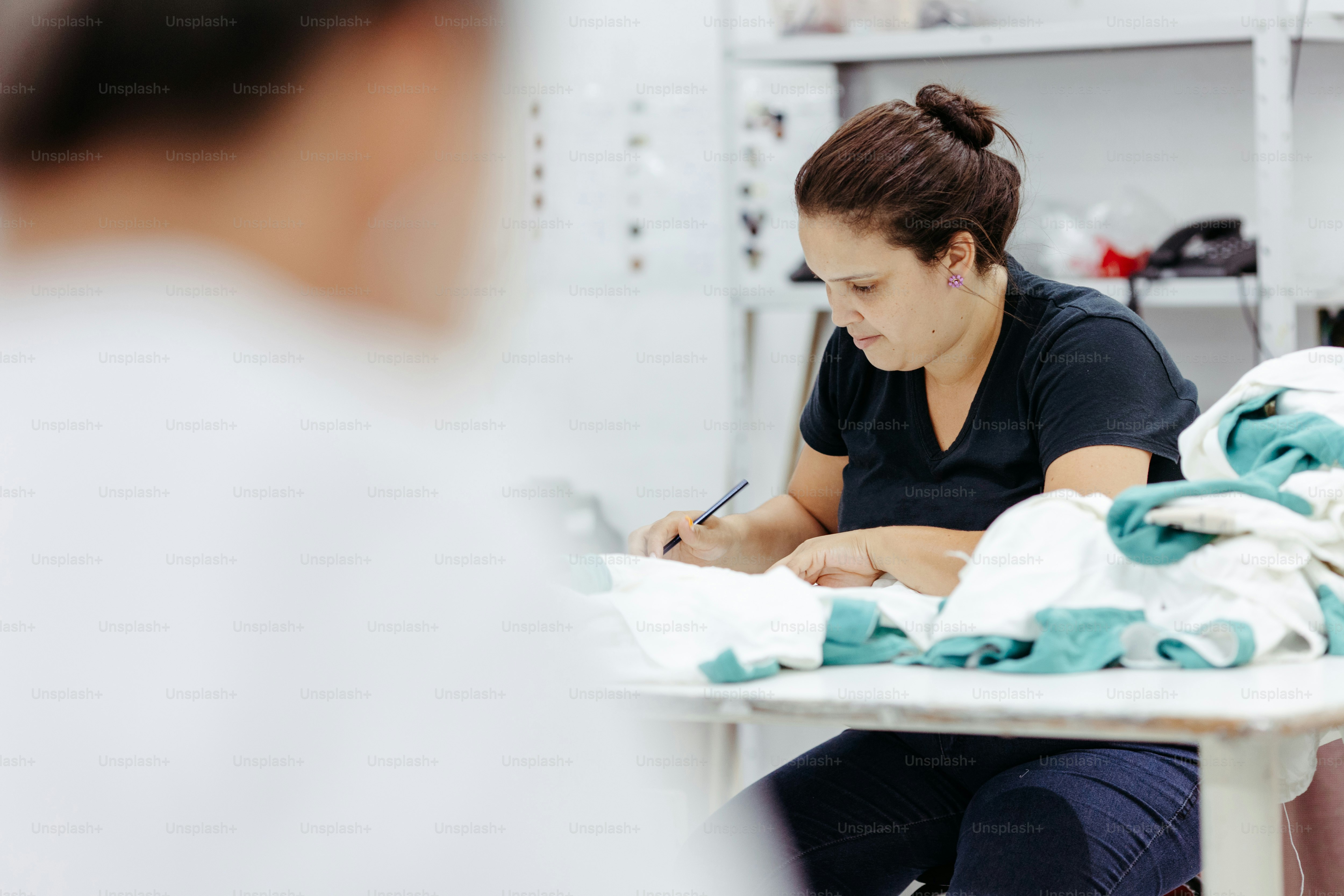 Una mujer sentada en una mesa escribiendo en un pedazo de papel