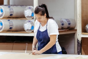 a woman in an apron working on a piece of wood